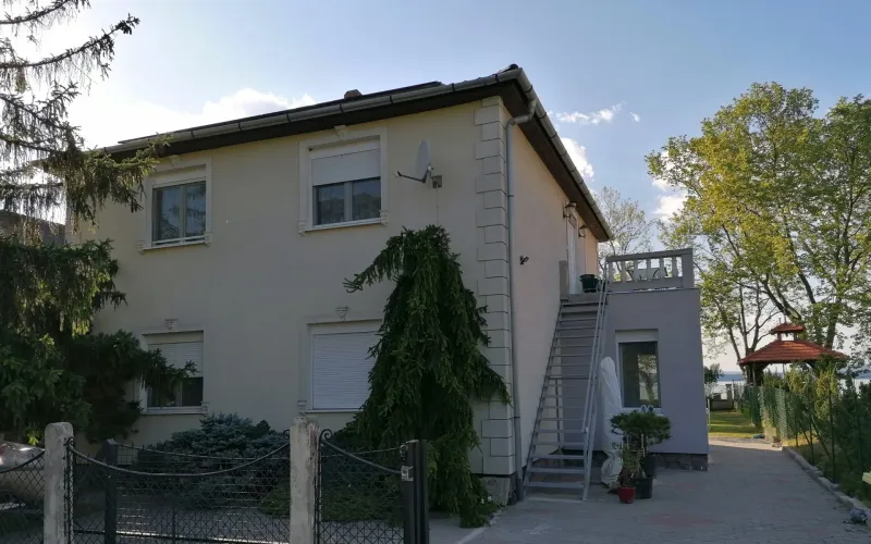 Az ÉvaLak Apartman épülete a kert felől, háttérben a Balaton