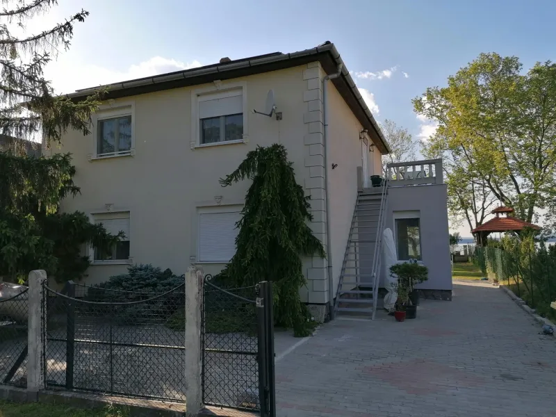 Az ÉvaLak Apartman épülete a kert felől, háttérben a Balaton